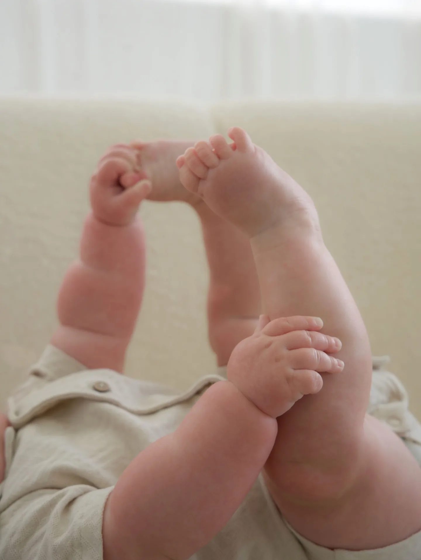 Close-up of a baby's feet and hands during a soft cream studio session
